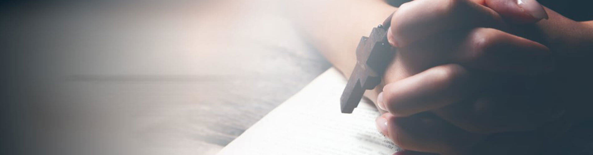 Praying hands over Bible
